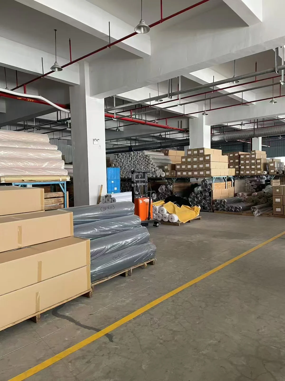 Packed fabric rolls and cartons in the warehouse